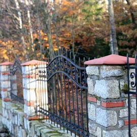 Natursteinmauer mit roten Pfeilerabdeckung
